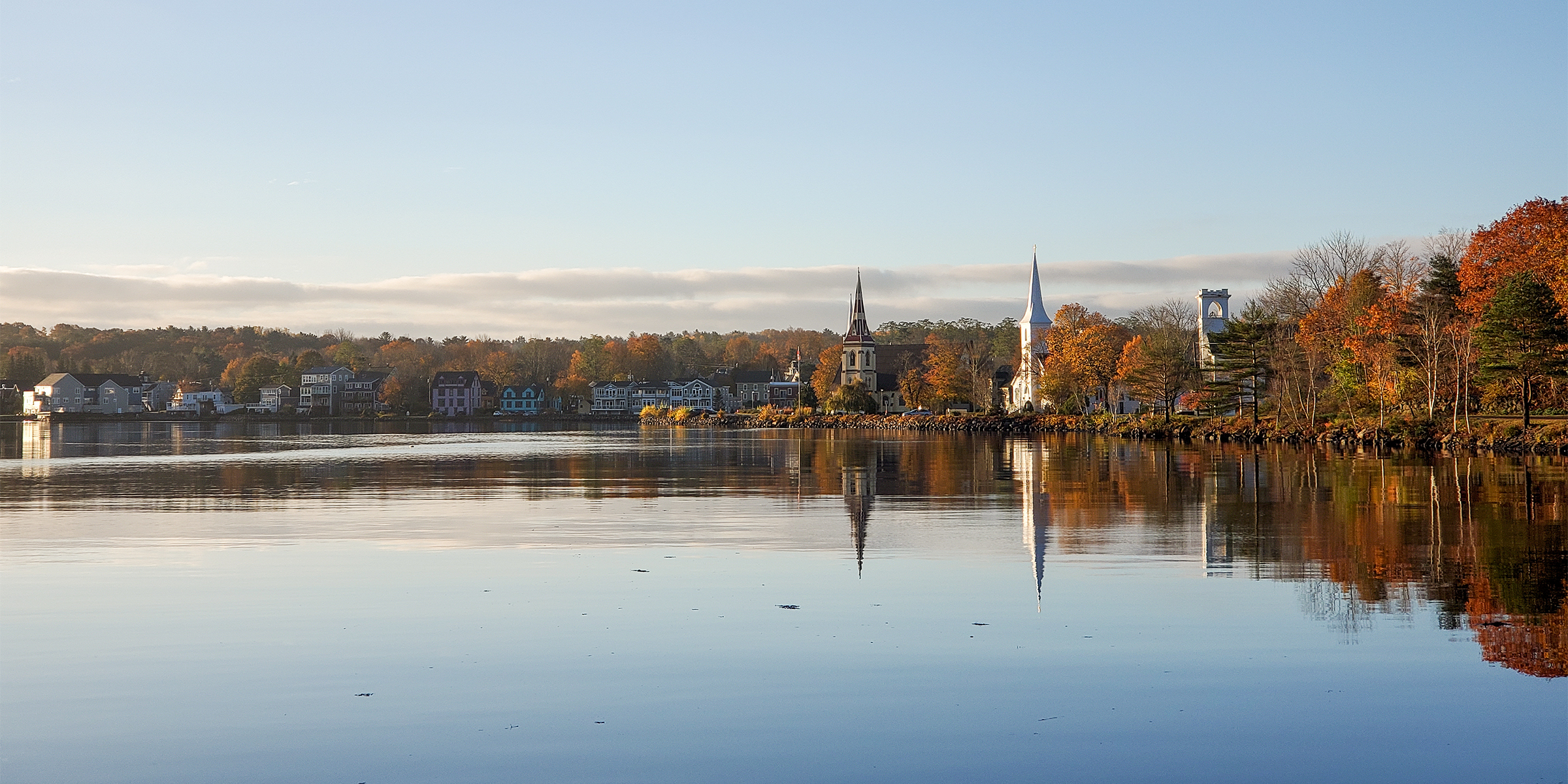 A printed Mahone Bay visitor map and a stack of Chamber brochures on a wooden counter